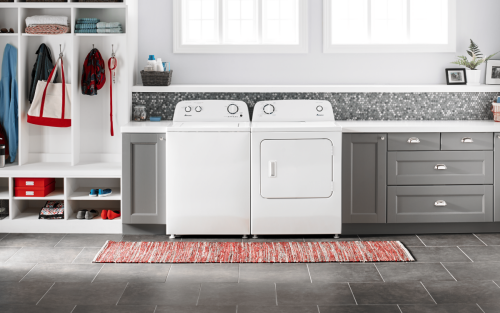 A white Amana® washer and dryer in grey cabinetry