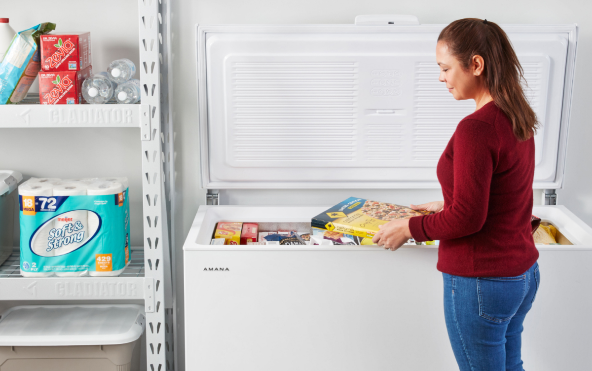 Person placing items in a chest freezer