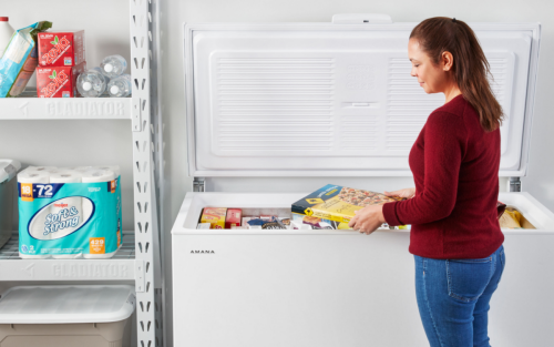 Person placing items in a chest freezer