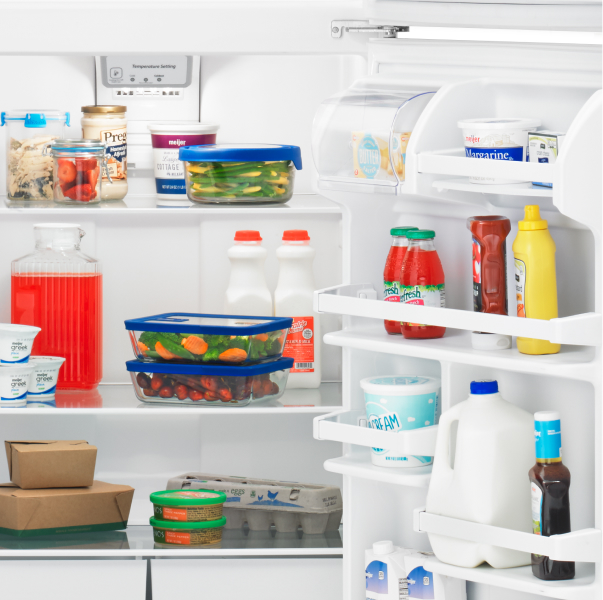 An open Amana® refrigerator with food inside.