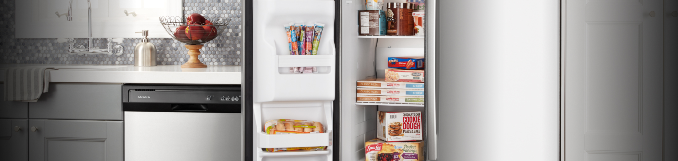 An Amana® dishwasher and open freezer door in a kitchen.