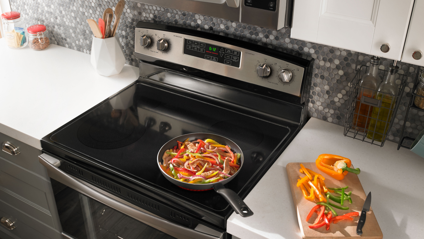 Food cooking on stovetop of stainless steel Amana® range