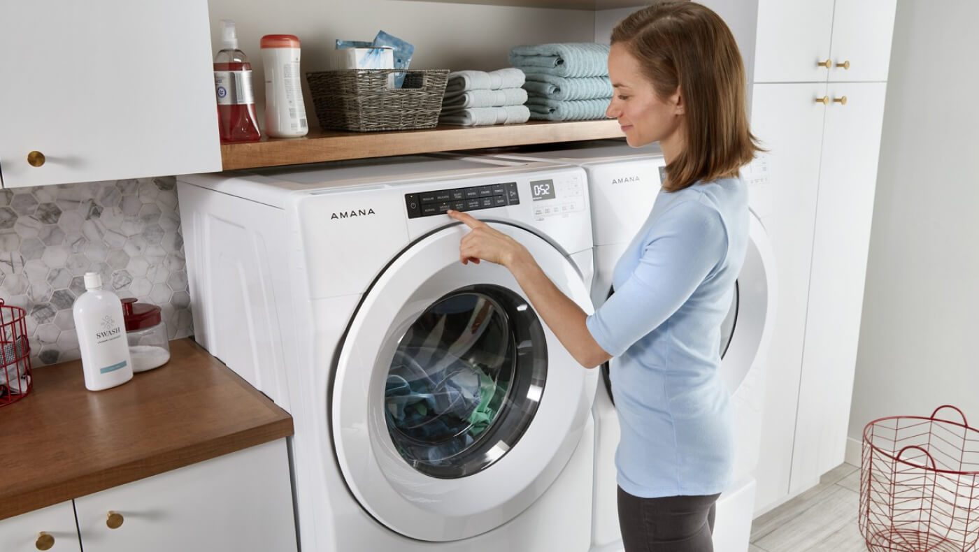 Person making a selection on a front load washing machine