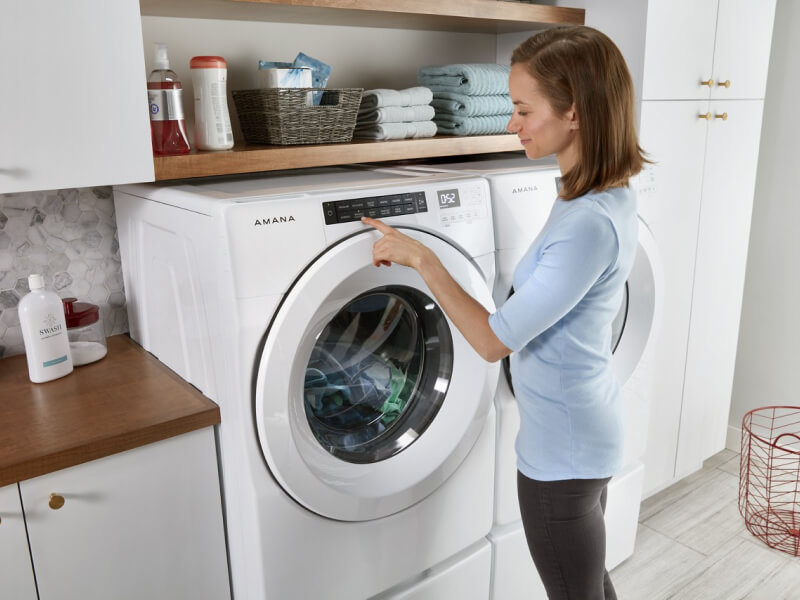 Person making a selection on a front load washing machine